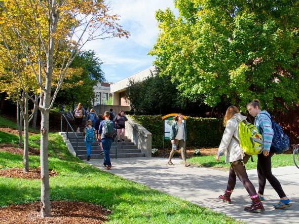 Students walking between Syracuse campus buildings in fall.